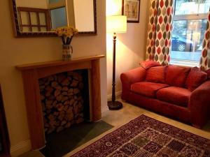 a living room with a red couch and a fireplace at Cathedral View in Salisbury