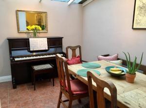 a dining room with a table and a piano at Cathedral View in Salisbury