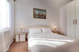 a bedroom with a white bed and a picture on the wall at Ca Biennale in Venice