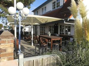 a patio with a table and chairs under an umbrella at Appartements Fischerhus in Glowe