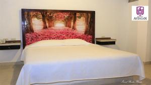 AtzalanにあるHotel Atzalanの花道の絵画が飾られたベッドルーム1室