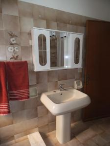 un bagno con lavandino bianco e 2 specchi di Le spezie 2PD a Castellammare del Golfo