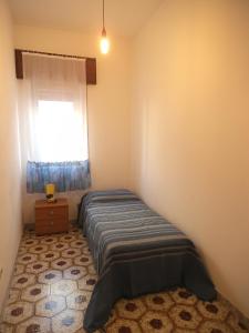 una piccola camera con letto e finestra di Le spezie 2PD a Castellammare del Golfo