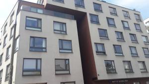 wysoki biały budynek z czarnymi oknami w obiekcie Charming studio Center of Krakow w Krakowie