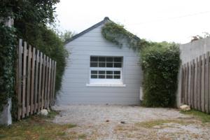 un garaje blanco con una ventana junto a una valla en Maison Kador, en Crozon