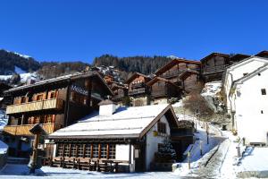 eine Skihütte mit Schnee auf dem Dach in der Unterkunft Hôtel Mélèze B & B in Grimentz