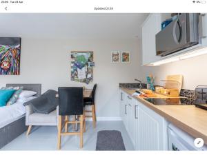 a kitchen with a table and chairs and a bed at The Studio Castlerock with Hot Tub in Coleraine