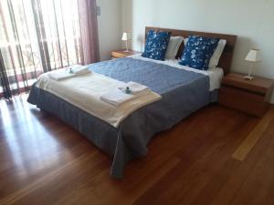 a bedroom with a bed with blue sheets and blue pillows at Casa do Sol - Entre o Mar e o Pinhal in Apúlia