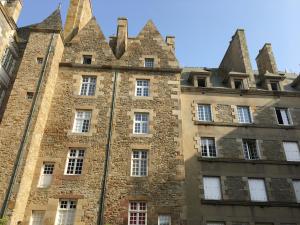 um antigo edifício de pedra com torres em Au chat qui danse, T2 tout confort Intra-Muros em Saint Malo