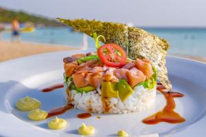 a sandwich on a plate with rice and tomatoes at Mayan Princess Beach & Dive Resort in West Bay