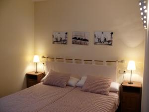 a bedroom with a white bed with two lamps at Apartamentos wifi Baqueira & Aigüestortes con jardín privado in Esterri d'Àneu