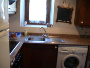 a kitchen with a sink and a washing machine at Apartamentos wifi Baqueira & Aigüestortes con jardín privado in Esterri d'Àneu +72 photos