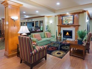 uma sala de estar com um sofá e uma lareira em Country Inn & Suites by Radisson, Oklahoma City at Northwest Expressway, OK em Oklahoma City