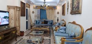 sala de estar con muebles azules y TV de pantalla plana en Maadi, Direct Nile river View From all Rooms en El Cairo