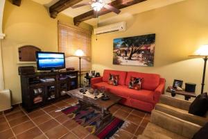 sala de estar con sofá rojo y TV en Casa Corazon FN 164, en Nopoló