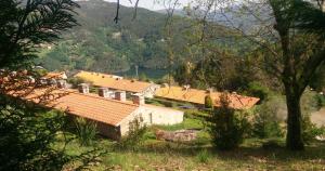 ヴィエイラ・ド・ミーニョにあるRefúgio dos Sentidos no Gerêsの山を背景にした家の風景