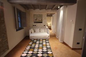 een woonkamer met een witte bank en een geruite vloer bij Dimora Carducci in Pietrasanta