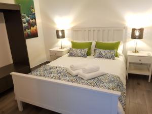 um quarto com uma cama branca e 2 candeeiros em Vieira Apartments II em Setúbal