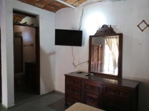 Habitación con espejo, tocador y TV. en Hotel Y Bungalows Islas Careyes en Los Ayala