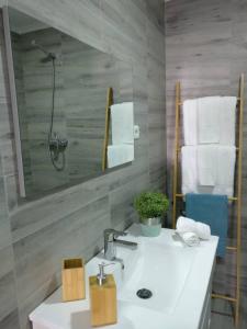 a bathroom with a sink and a mirror and towels at V4 in Horta +35 photos
