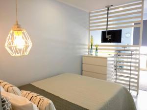een slaapkamer met een bed, een dressoir en een televisie bij V4 in Horta