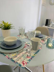 a white table with plates and cups on it at V4 in Horta