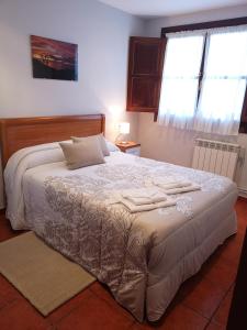 1 dormitorio con 1 cama con 2 toallas en Apartamentos La Tarazana 4 en La Pereda de Llanes