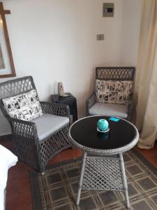 uma sala de estar com duas cadeiras e uma mesa com uma tigela em Turquesa em El Quisco