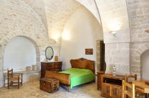 a bedroom with a bed and a table and a mirror at Agriturismo Antonelli Piangevino in Monopoli
