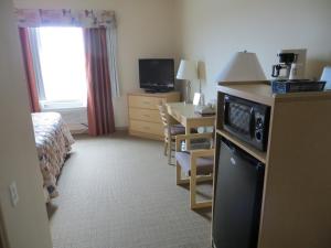 a hotel room with a bed and a desk and a room at Lone Star Hotel in North Battleford