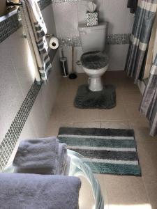 a bathroom with a toilet and towels on the floor at A&D Tennis Villa in Arnos Vale