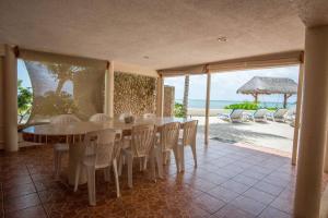 a dining room with a table and chairs and the ocean at CASA TORTUGA, Soliman Bay in Tulum