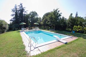 una piscina con 2 sillas y una sombrilla en Il Ducato, en Cortona