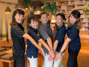 a group of women posing for a picture in a library at Guest House Chura Cucule Ishigakijima in Ishigaki Island
