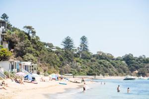 a group of people on a beach in the water at Portsea Hotel in Portsea