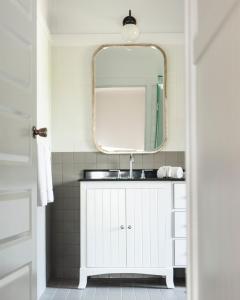 La salle de bains est pourvue d'un lavabo et d'un miroir. dans l'établissement Portsea Hotel, à Portsea