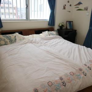 een slaapkamer met een wit bed en blauwe gordijnen bij Alaha Blue Resort 6F -SEVEN Hotels and Resorts- in Chatan