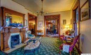 a living room with a fireplace and chairs and a mirror at The Hancock House Bed & Breakfast Inn in Dubuque