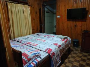 um quarto com uma cama com uma colcha em Nayta villa Lolai toraja em Rantepao