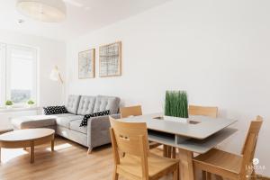 a living room with a table and a couch at Jantar Apartamenty - Holiday Polanki Park SPA in Kołobrzeg