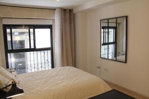 阿利坎特的住宿－Sunny Apartments, Historical Centre Alicante，一间卧室设有一张床和一个大窗户