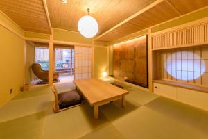 a living room with a wooden table and a chair at Hanaikada in Kyoto