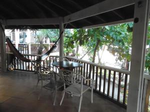 a hammock on a porch with a table and chairs at Fosters West Bay Resort in West Bay
