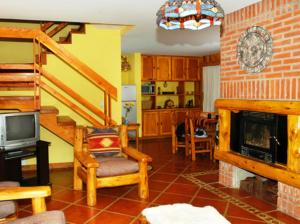sala de estar con escalera y chimenea en Cabañas Aquelarre Catedral en San Carlos de Bariloche