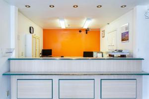 an empty waiting room with an orange wall at Motel 6-Espanola, NM in Espanola