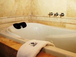 y baño con bañera y toalla. en Cabañas Aquelarre Catedral en San Carlos de Bariloche