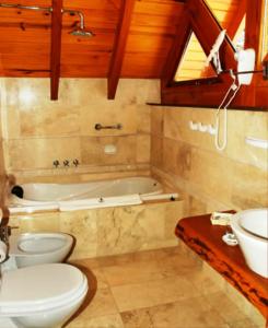 y baño con aseo, lavabo y bañera. en Cabañas Aquelarre Catedral en San Carlos de Bariloche