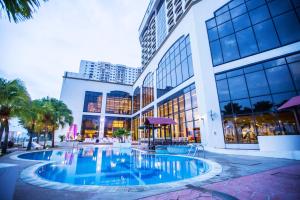 a large building with a pool in front of it at Grand Riverview Hotel in Kota Bharu