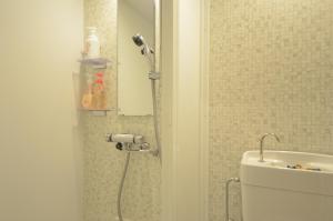 a shower in a bathroom with a toilet and a sink at Sobe House in Yomitanson in Yomitan