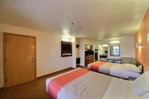 a hotel room with two beds and a flat screen tv at Motel 6-Edinburg, TX in Edinburg